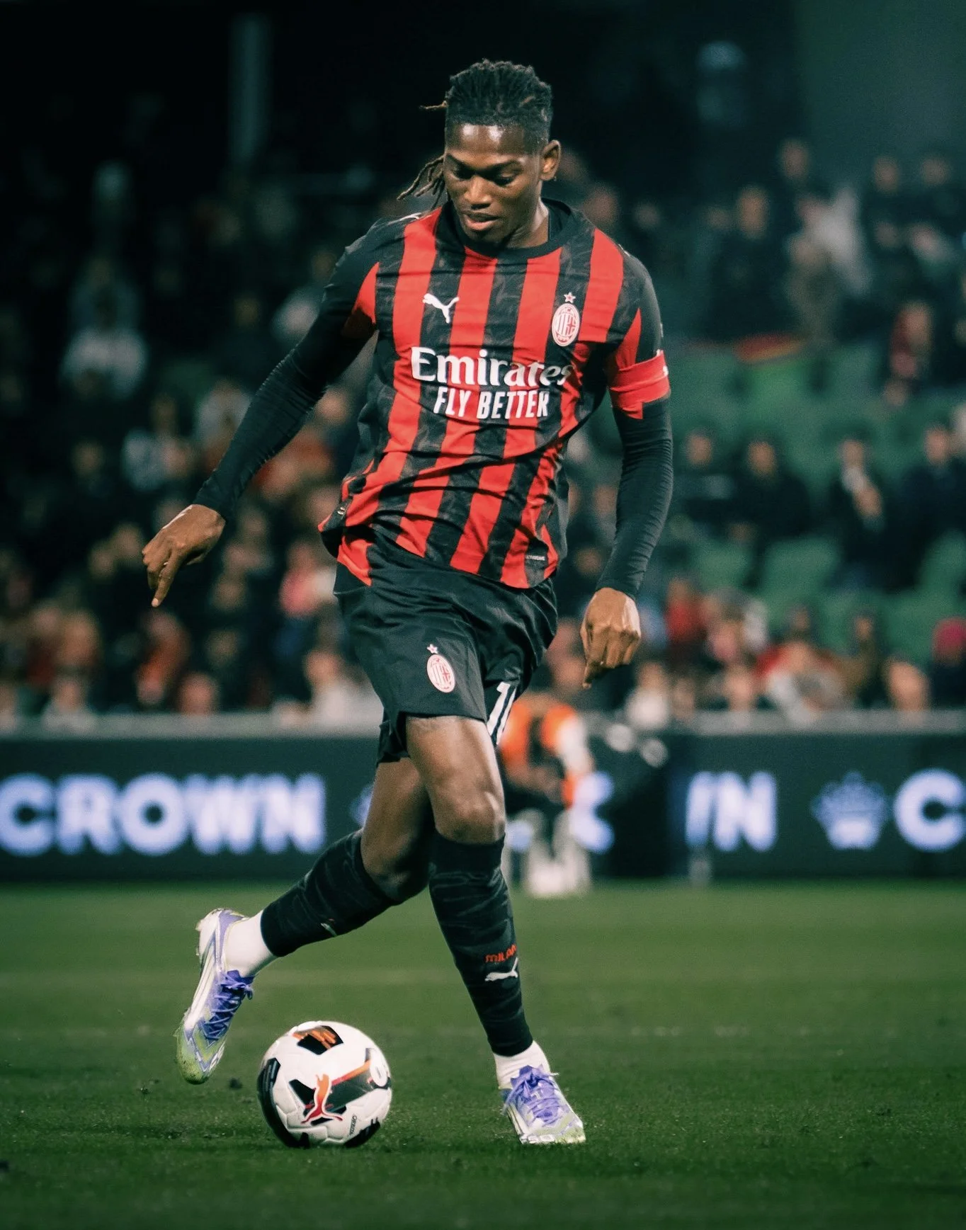 AC Milan player kicking a ball at night
