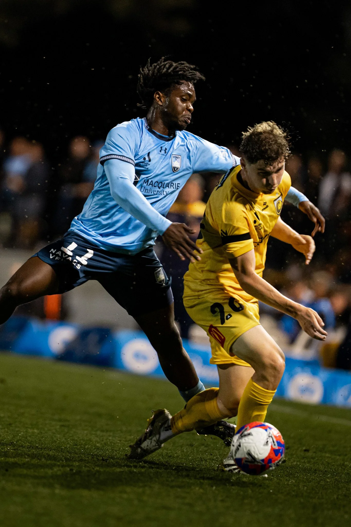Two players competing for the ball at night