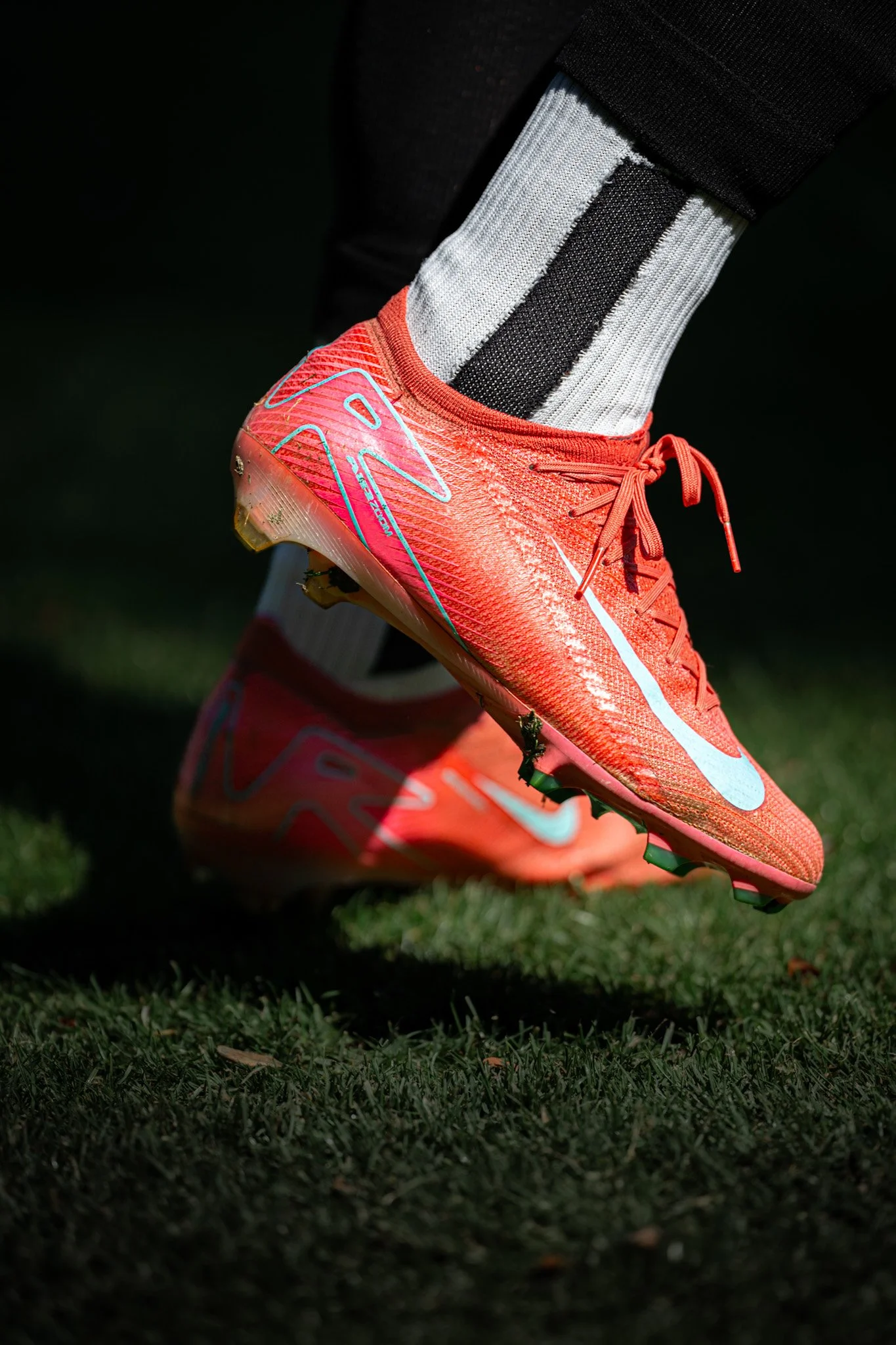 Close-up of a soccer cleat on grass