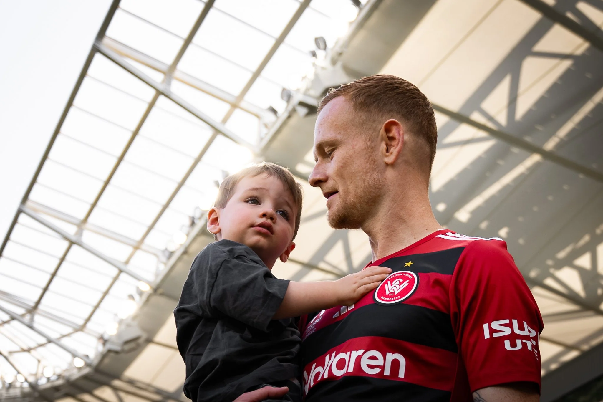 Player holding a child inside the stadium