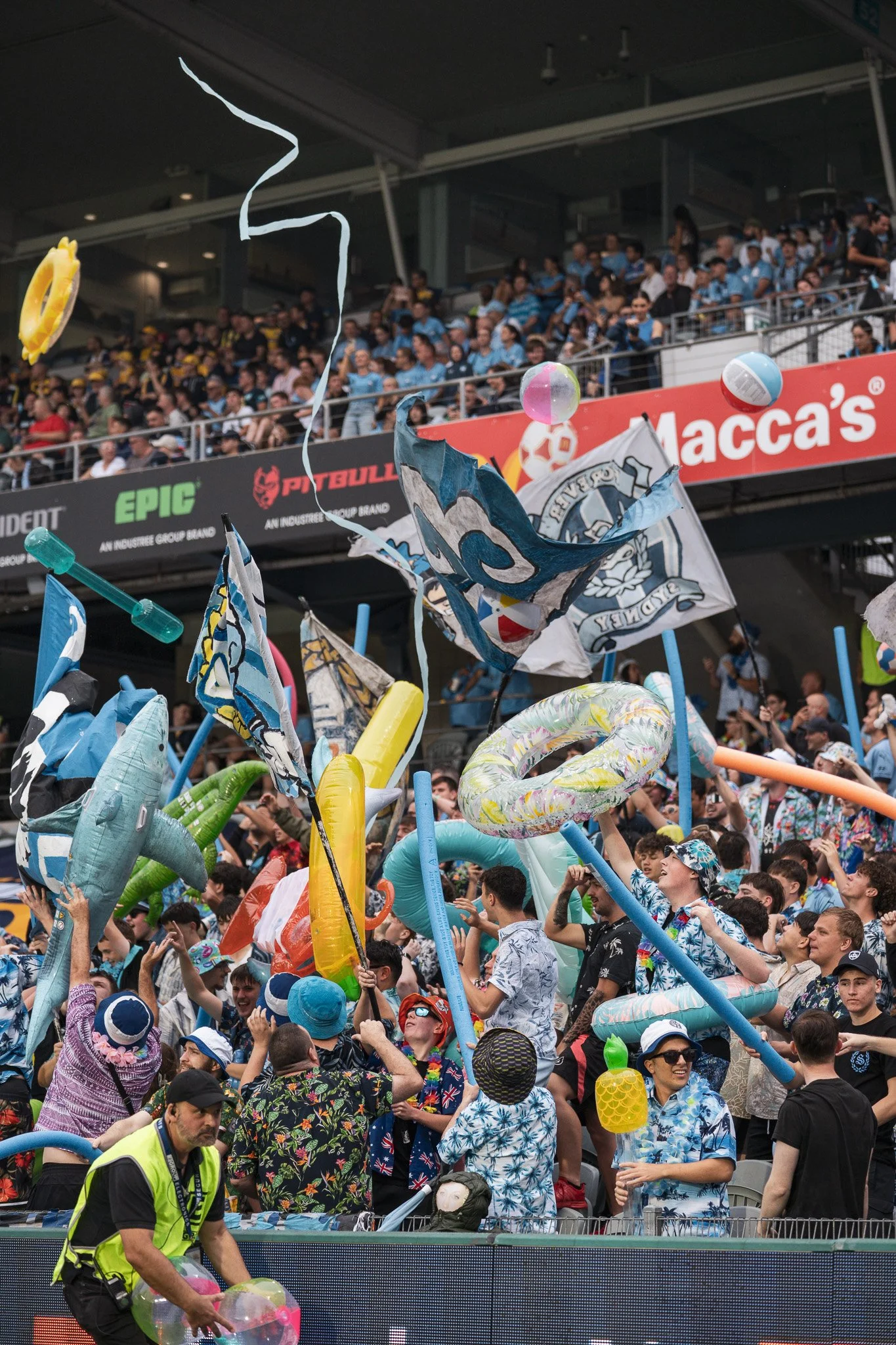 Crowd celebrating with inflatables and flags