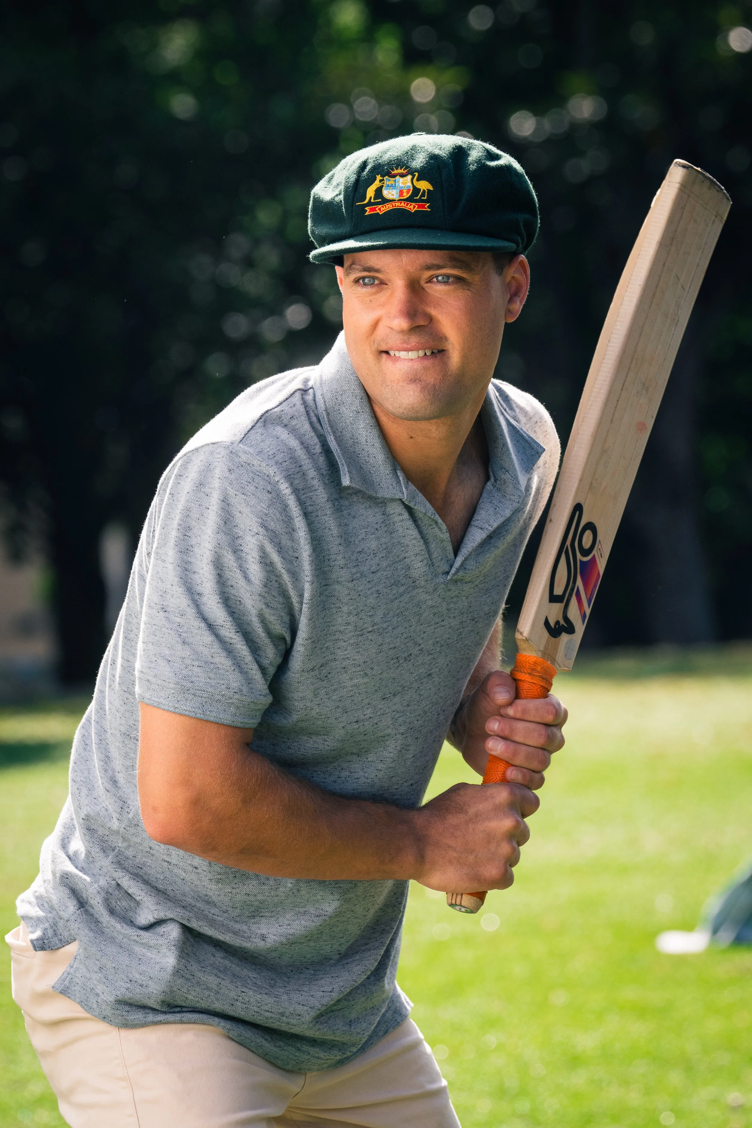 Cricketer with bat and green cap