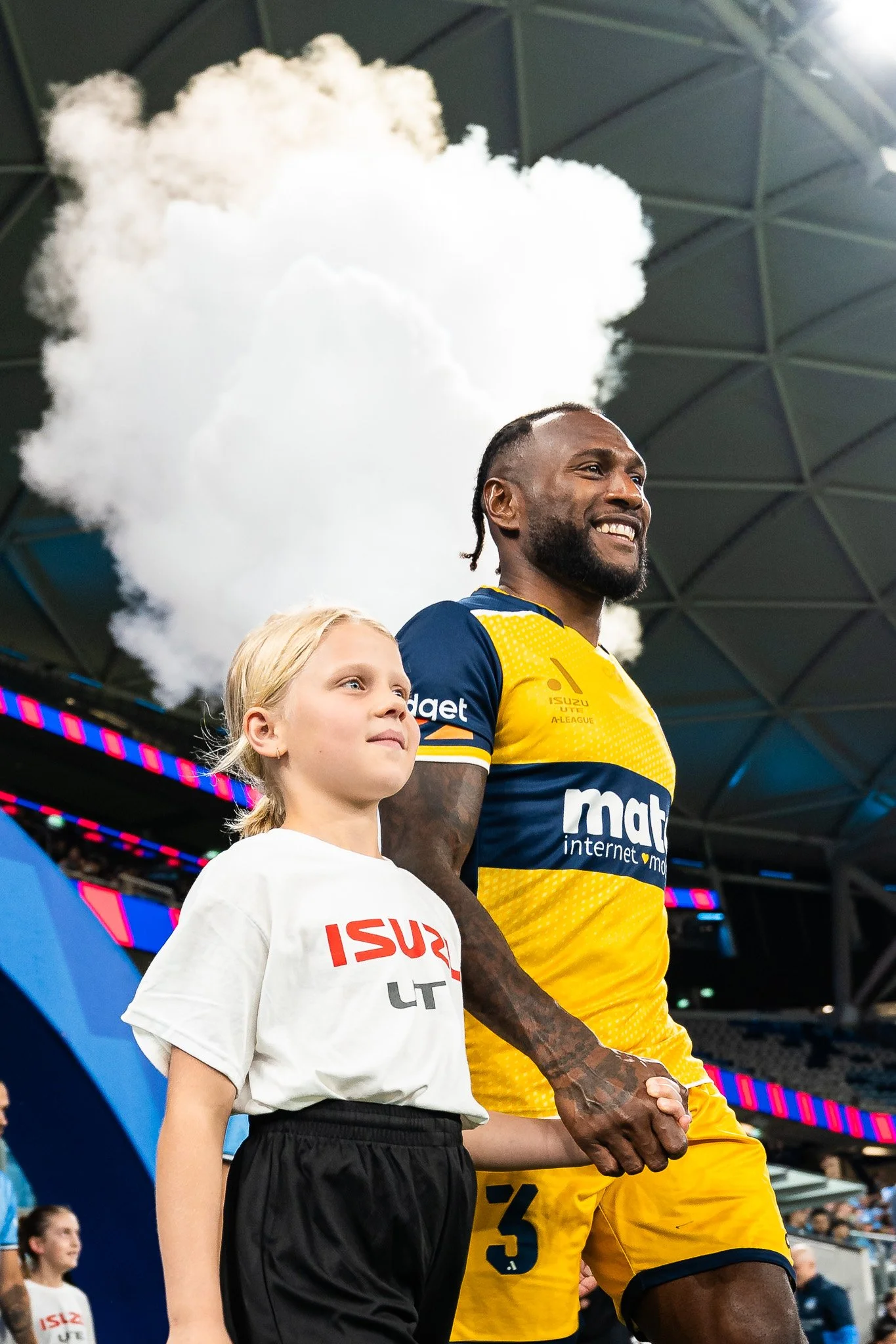Rugby player and young girl in stadium smoke