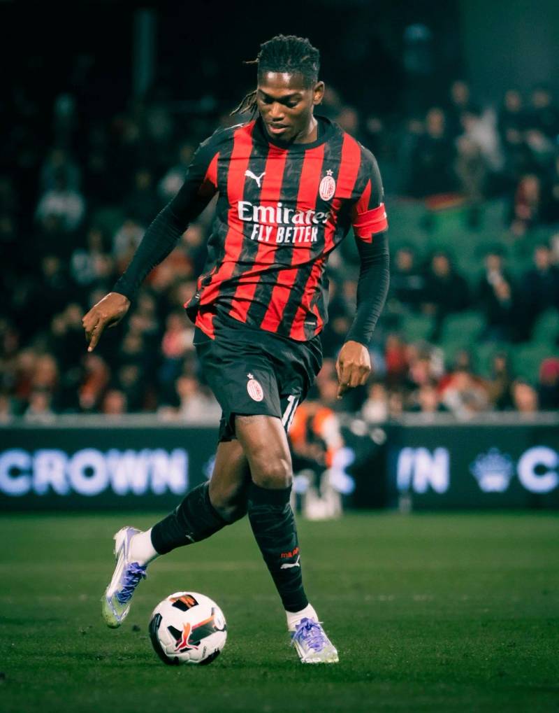 AC Milan player kicking a ball at night